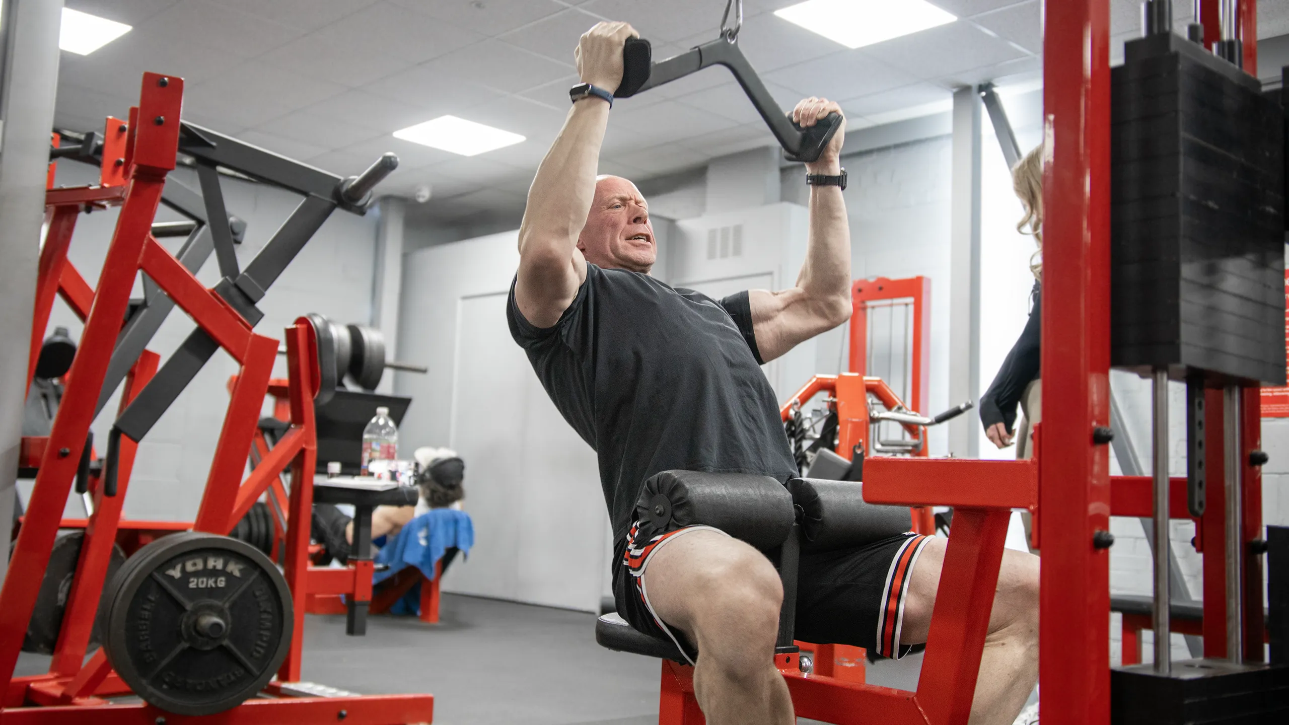 A member training hard on a plate-loaded pulldown at RP Fitness in Cambridge