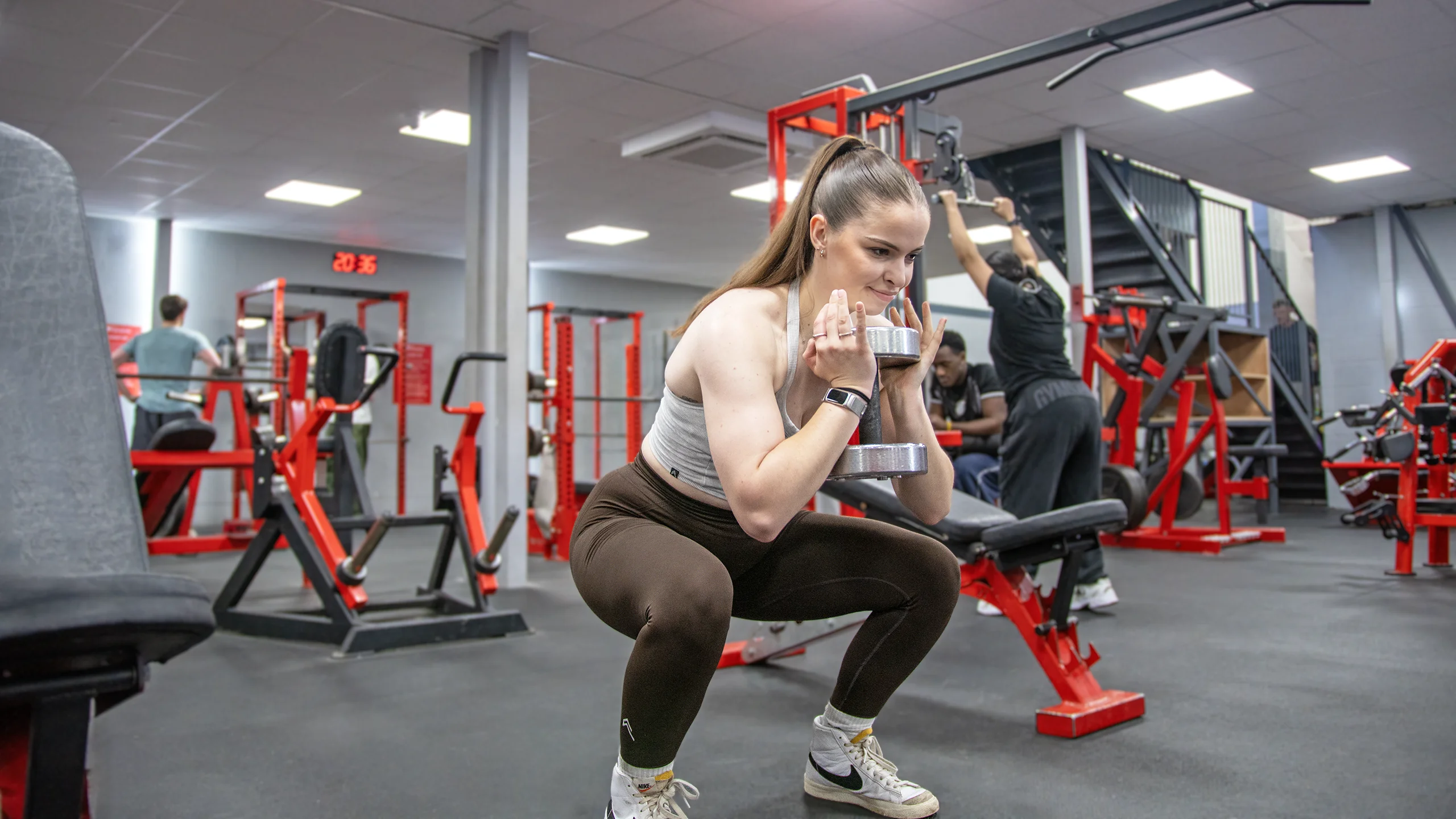 A trainer coaching on the weights floor at RP Fitness, an independent 24/7 gym in Cambridge
